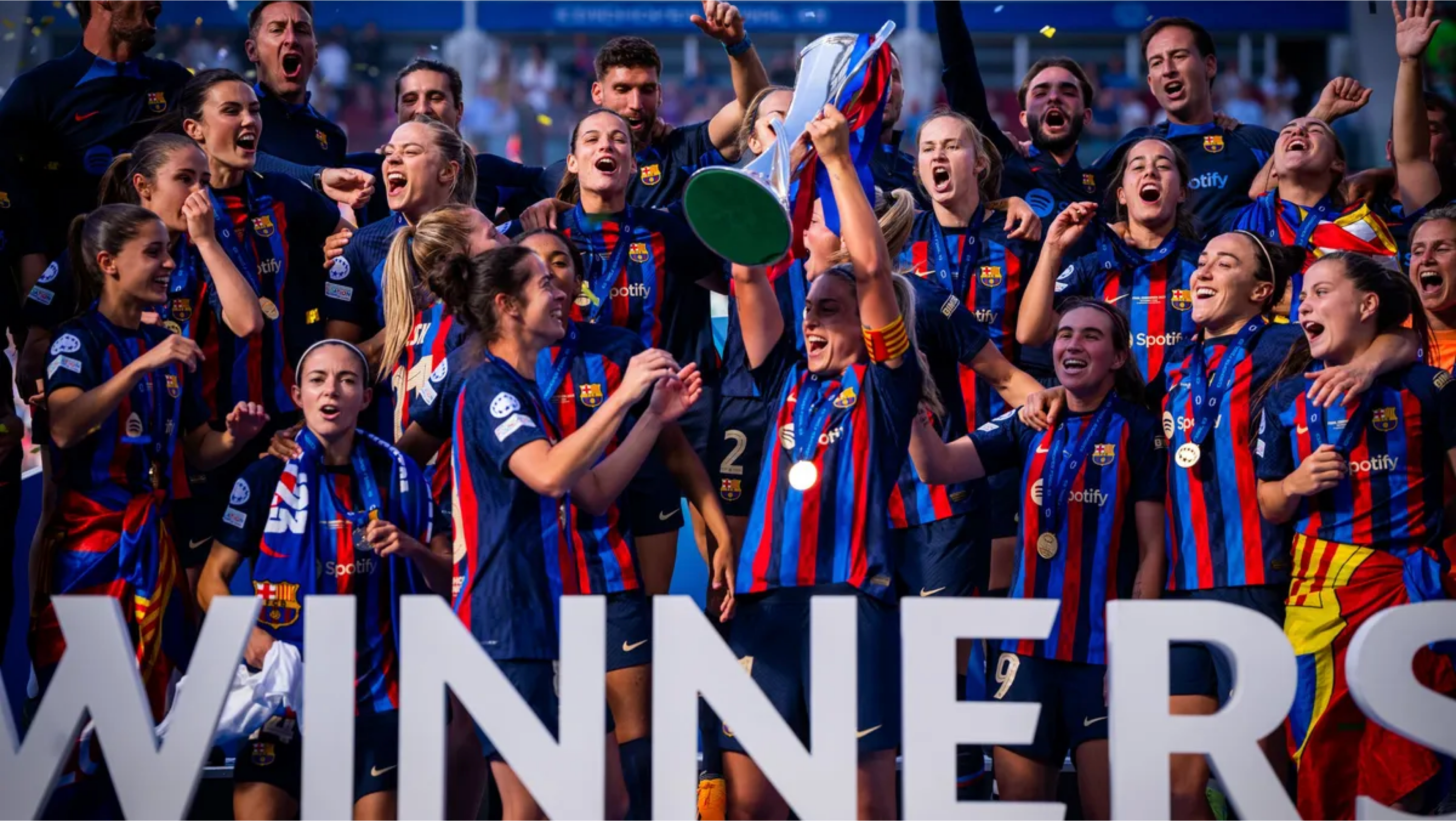 A football team celebrating with a trophy